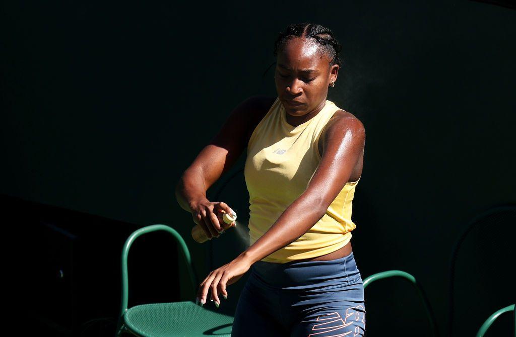 Coco Gauff applies sun cream to her left arm during a pause in a practice session at the 2025 French Open