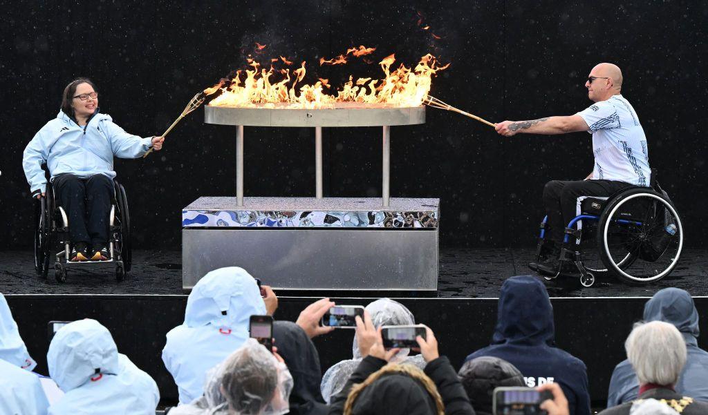 Helene Raynsford and Gregor Ewan lighting the Paralympic flame. 