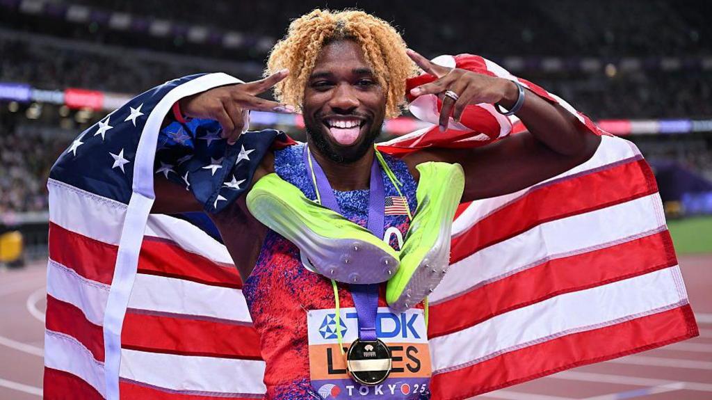Noah Lyles with the USA flag and gold medal