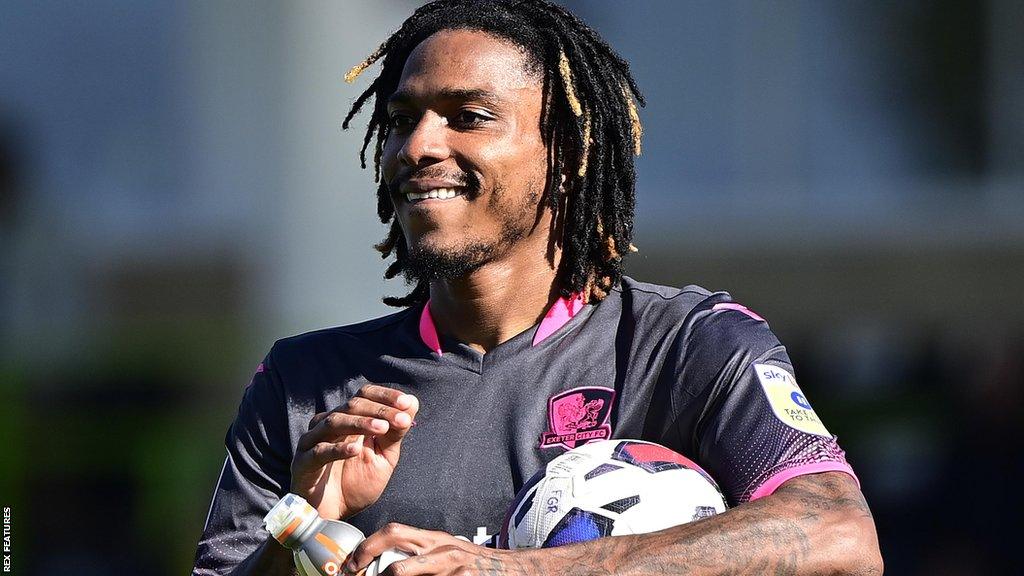 Jevani Brown smiling and holding a ball