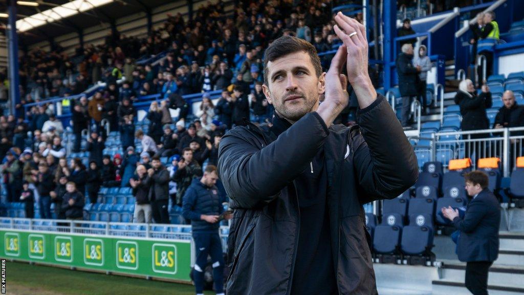 Portsmouth head coach John Mousinho claps supporters after his first game in charge in January 2023.