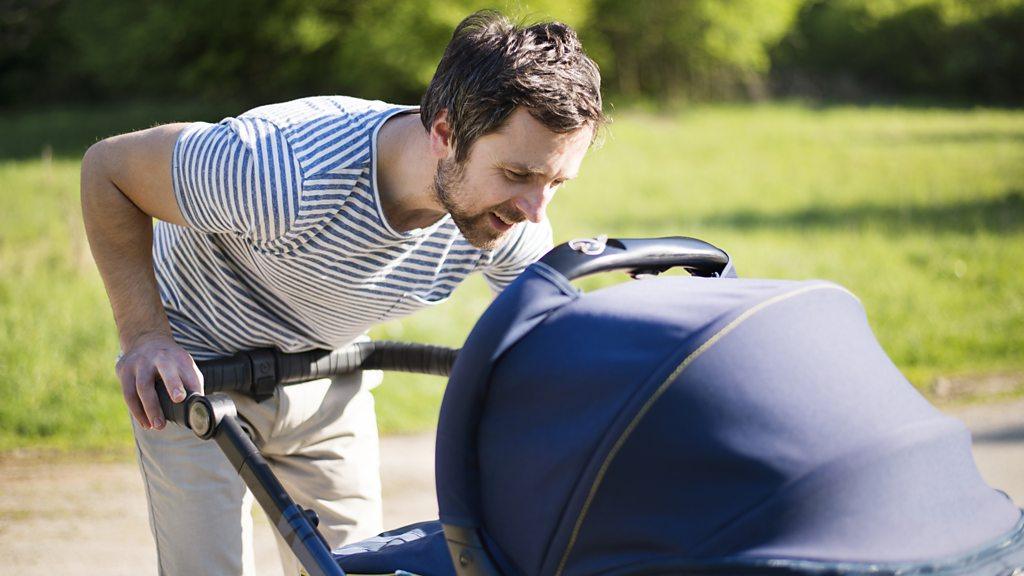 Father looking at baby in a pram