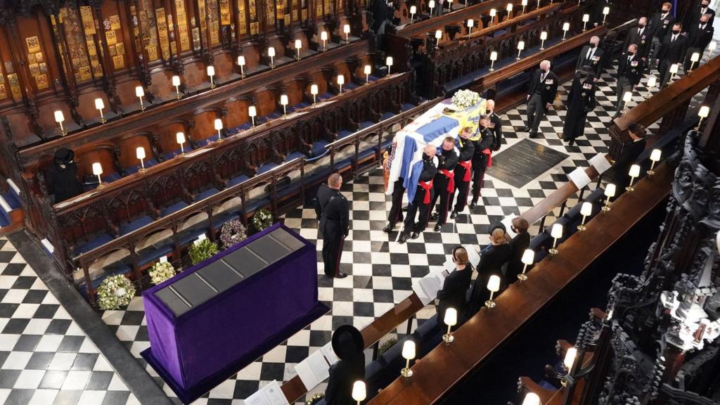 Queen Elizabeth II watches as the coffin of the Duke of Edinburgh is placed St George"s Chapel, Windsor Castle, Berkshire during his funeral service