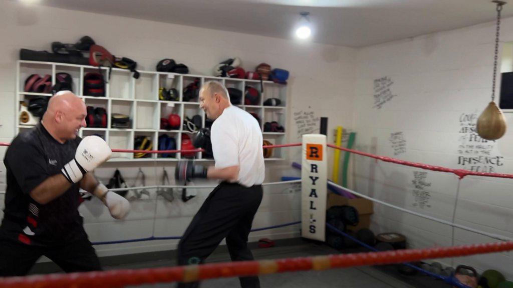 Two men training in a red boxing ring