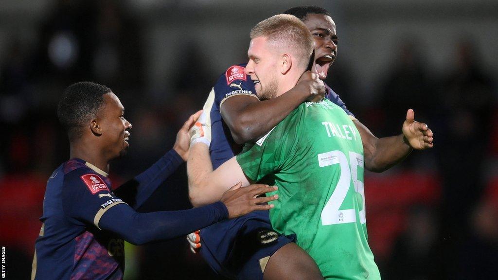 Peterborough players celebrate winning on penalties in the FA Cup first-round replay against Salford City