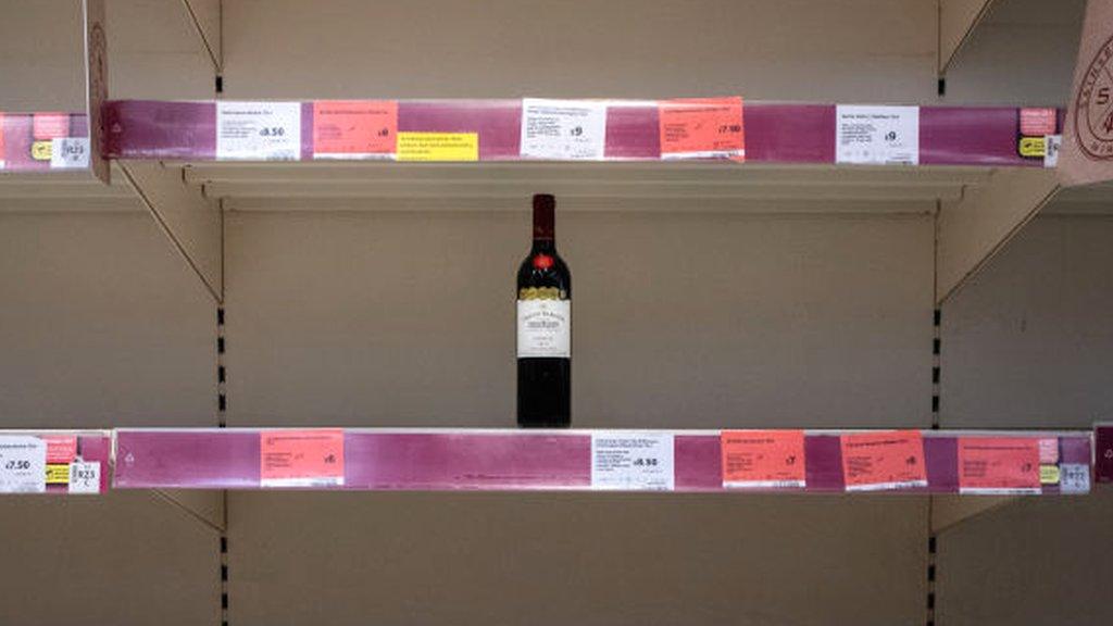 Bottle of wine on an empty supermarket shelf