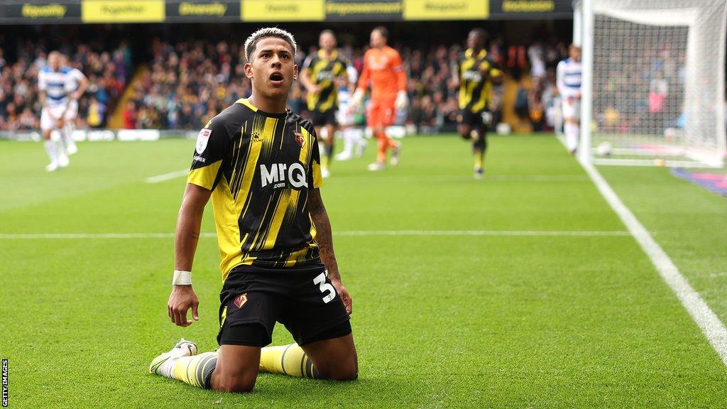 Matheus Martins celebrates scoring for Watford against Queens Park Rangers by sliding on his knees towards the corner flag