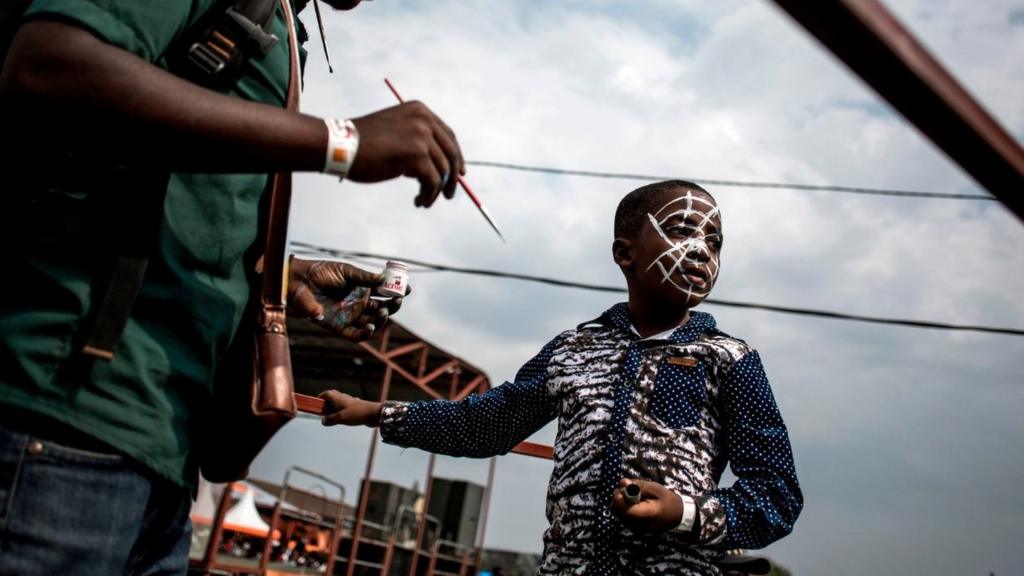 A young Congolese festival-goer gets his face painted during the Amani Festival on February 10, 2018 in Goma