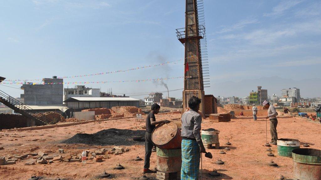 Workers pouring coal into the oven of the improved kiln