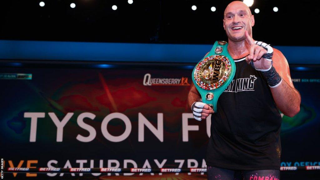 Tyson Fury holds his WBC title during a training session