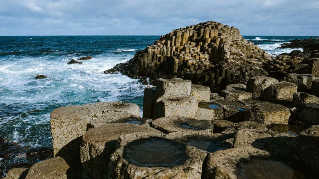 Giant's Causeway seen with waves from the sea crashing against it 