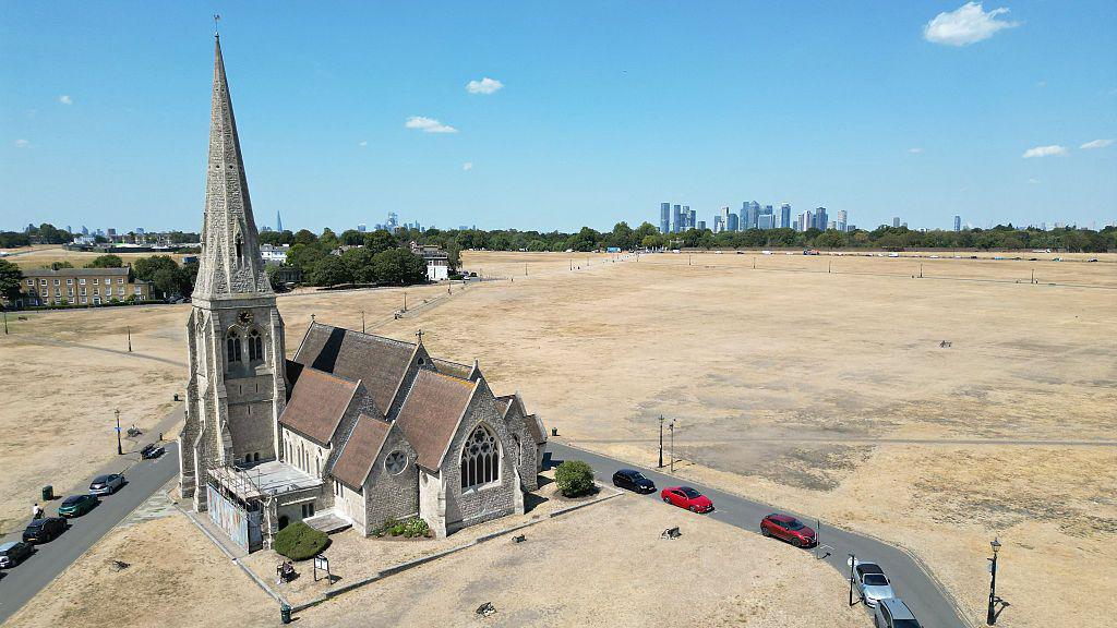 This aerial image shows All Saints Church surrounded by the scorched grass on Blackheath in south east London.