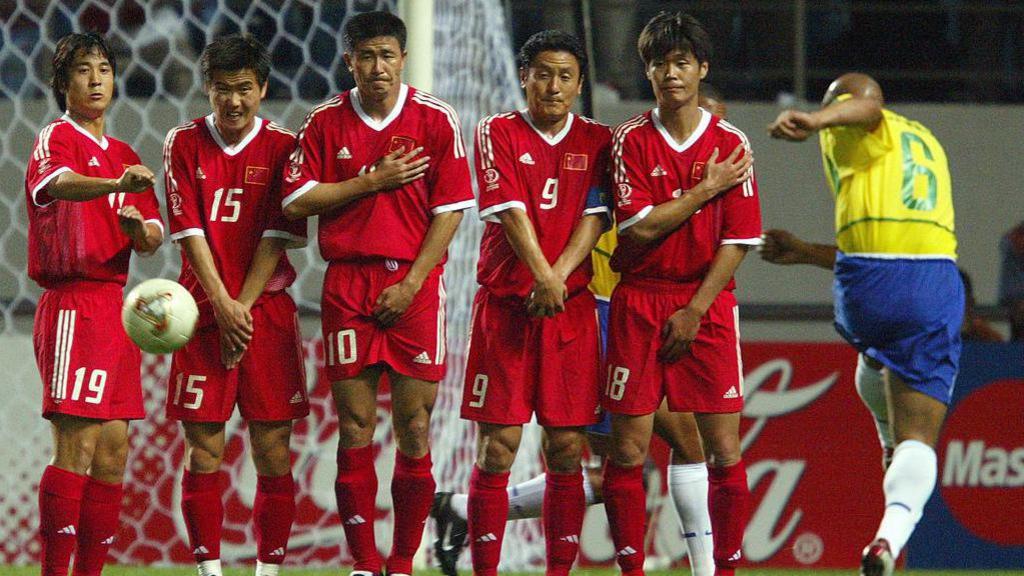 Chinese players grimace as Brazil's Roberto Carlos (right) unleashes a 14th minute free-kick for a goal during the 2002 World Cup