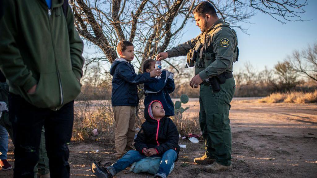 Border Patrol officer with migrant children. 