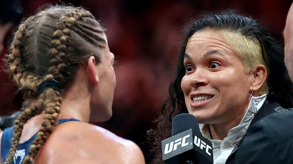 Amanda Nunes smiles broadly as she speaks to Kayla Harrison