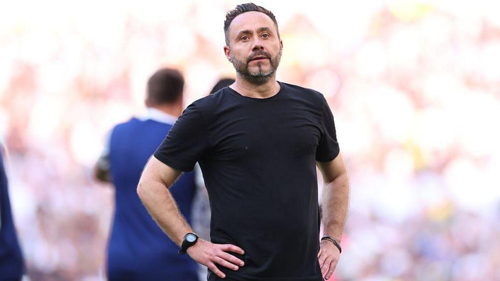 Roberto de Zerbi with his hands on his hips on the touchline