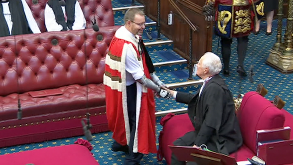 Baron Mackinlay of Richborough in formal robes shaking hands in the House of Lords.