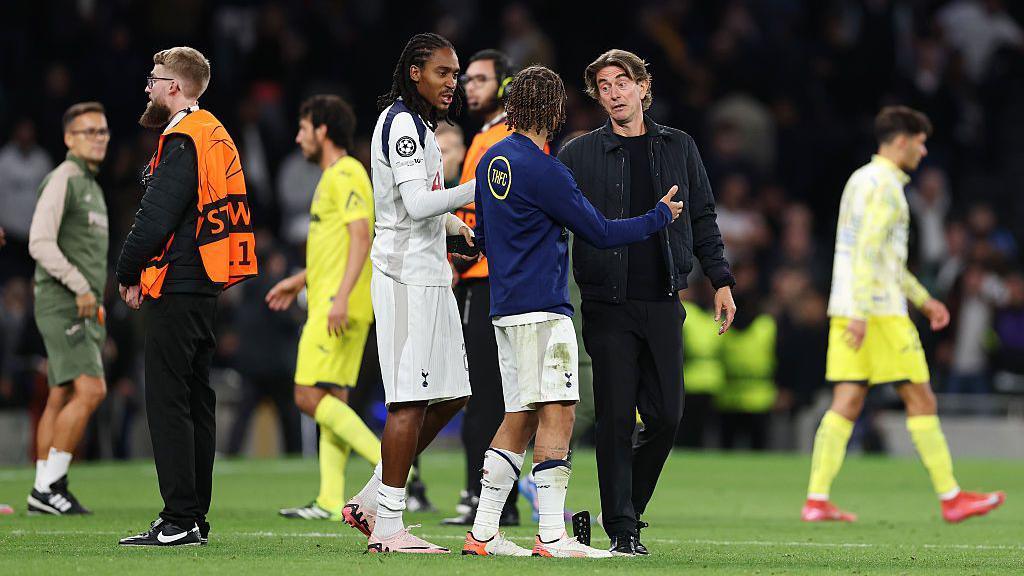 Thomas Frank speaks with Xavi Simons and Djed Spence on the pitch after the win against Villarreal