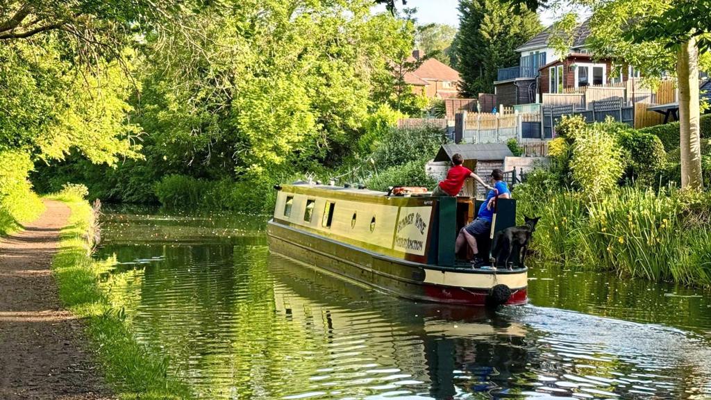 Barge on canal with sunshine through trees