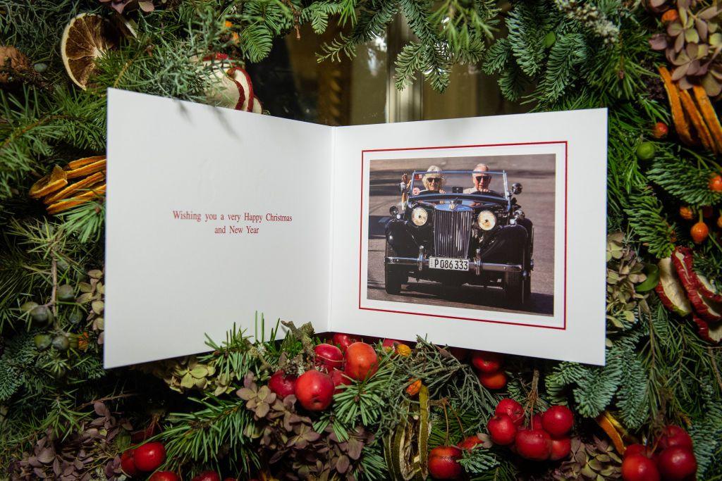 Prince Charles's Christmas card from 2019, featuring the prince driving a classic sports car, with Camilla sitting in the front passenger seat. The message says: Wishing you a very Happy Christmas and New Year.