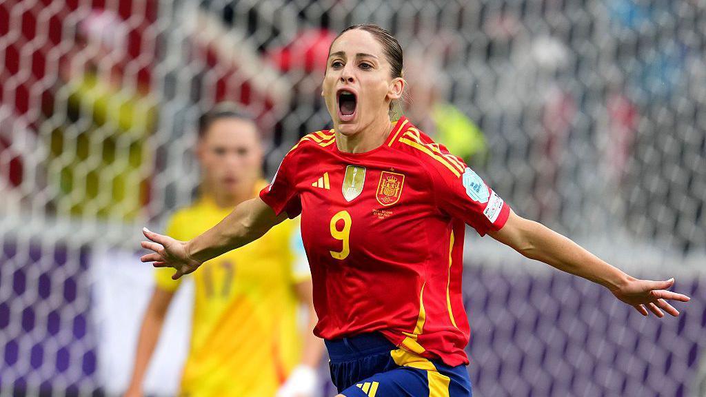 esther González wearing Spain's red and navy home kit celebrating after scoring a goal
