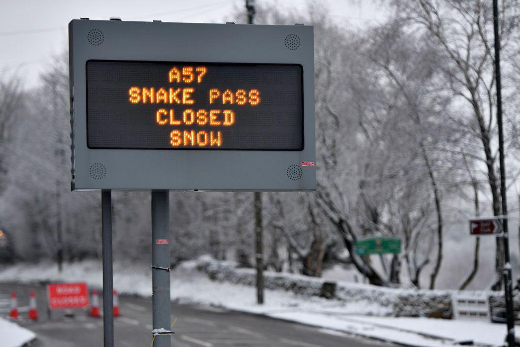 A sign saying the road is closed due to snow