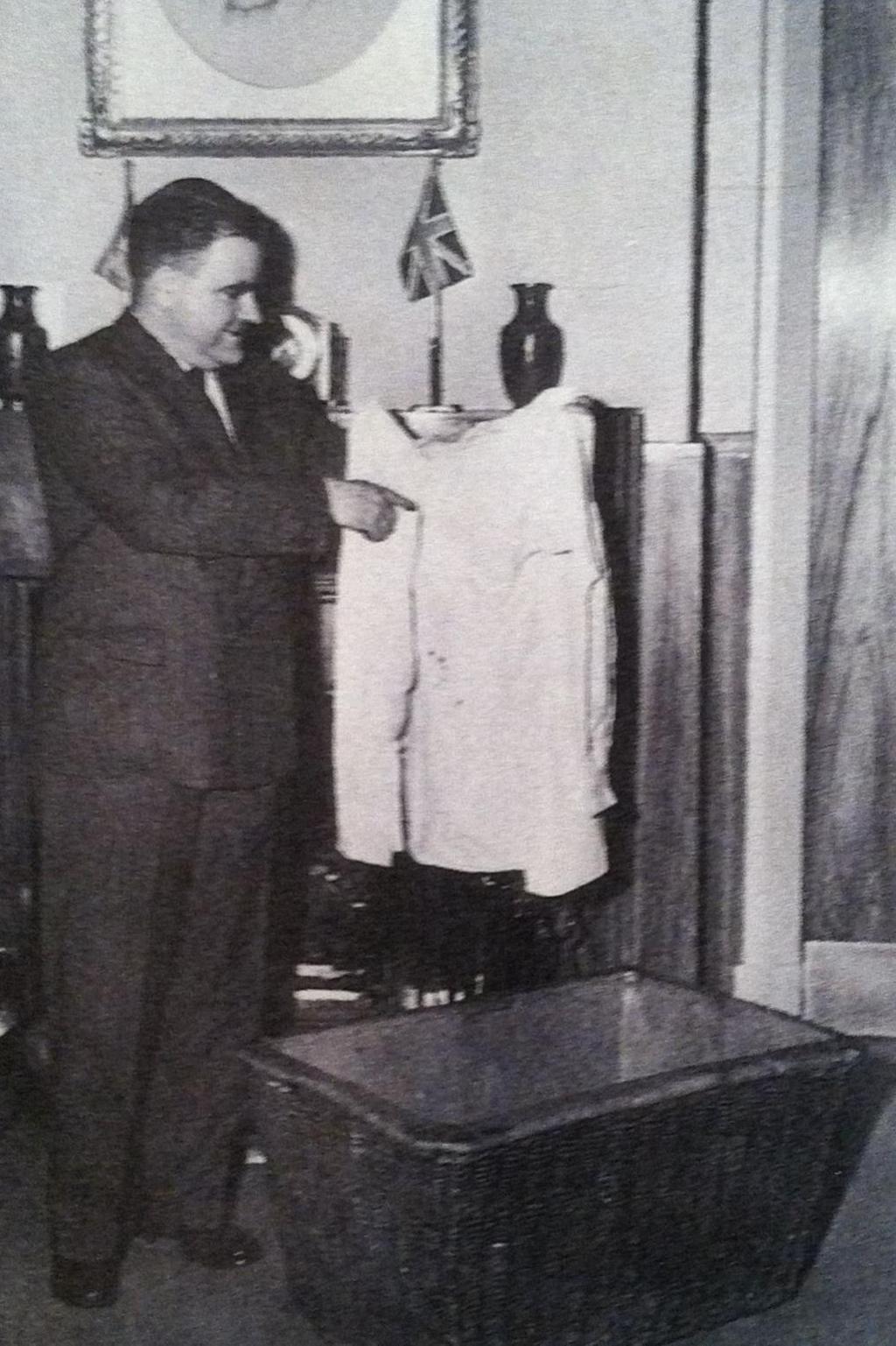 An unknown man - pictured with the basket James is said to have floated in - holds up the brother's shirt