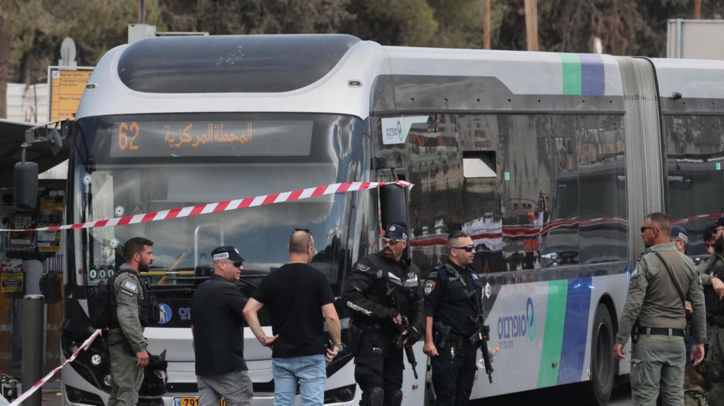 Israeli police officers next to a bus as they work at the scene of a shooting