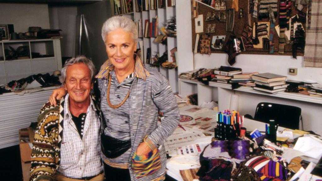 Italian fashion designer Ottavio Missoni and his wife Rosita Jelmini in the office of their fashion house in Sumirago. Both have short grey hair and wear signature Missoni knitwear. 