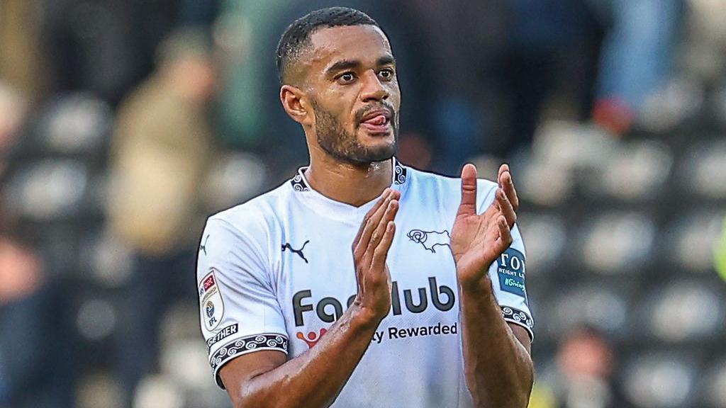 Derby defender Curtis Nelson applauds the Rams' fans