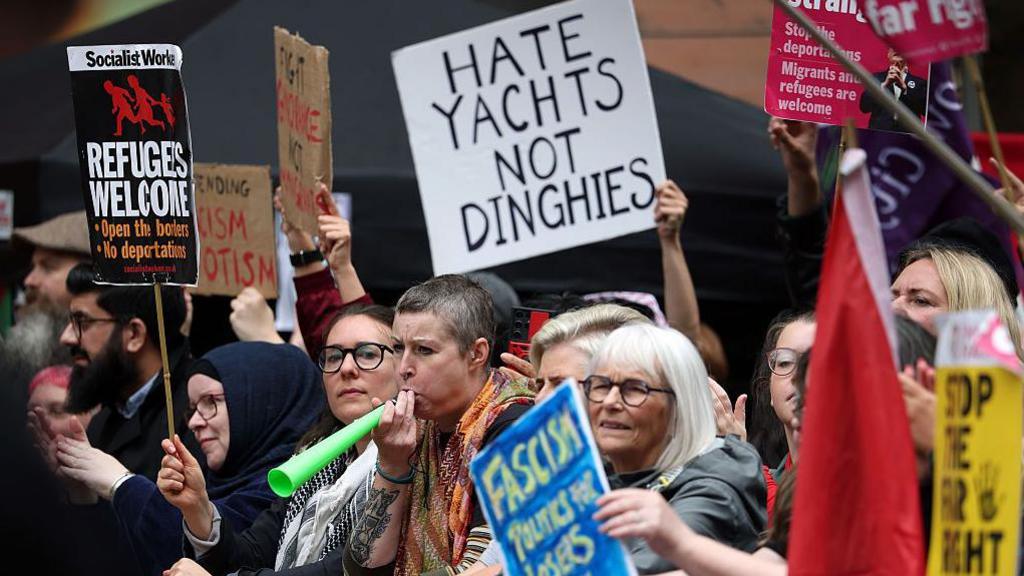 Counter-protesters from Take Back The Streets demonstrate against a rally protesting about immigration in Glasgow on 20 September.