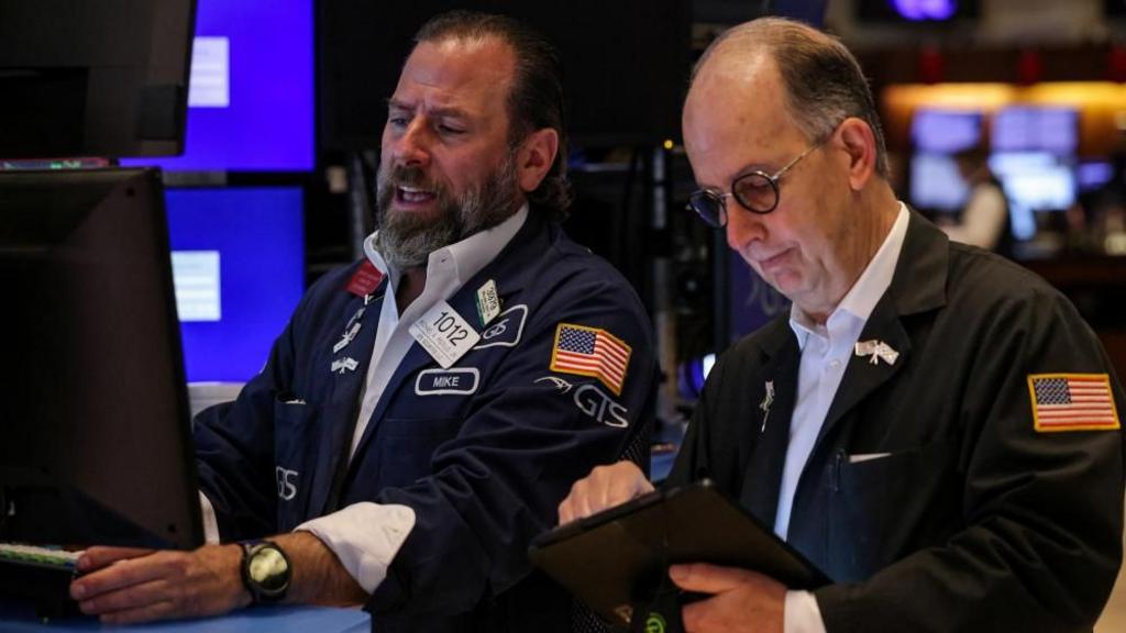 Traders work on a trade terminal at the New York Stock Exchange