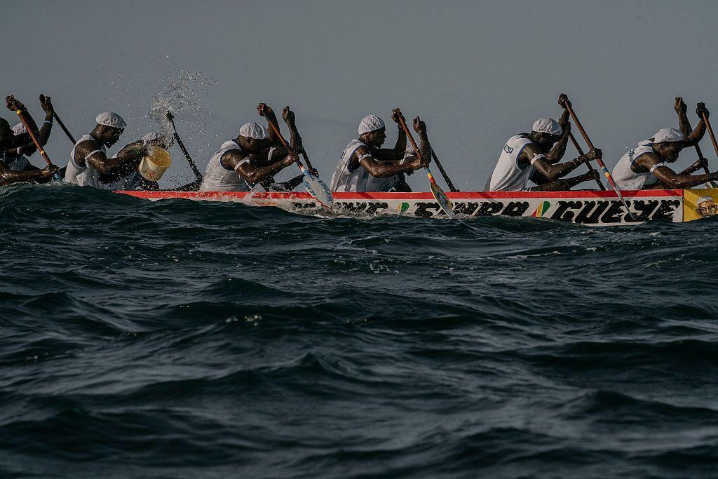 Men paddle in a large, wooden fishing canoe in Ngor on 18 October.