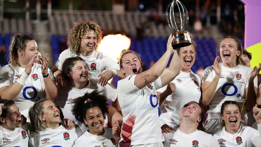 Marlie Packer lifts the WXV1 trophy surrounded by her England team-mates