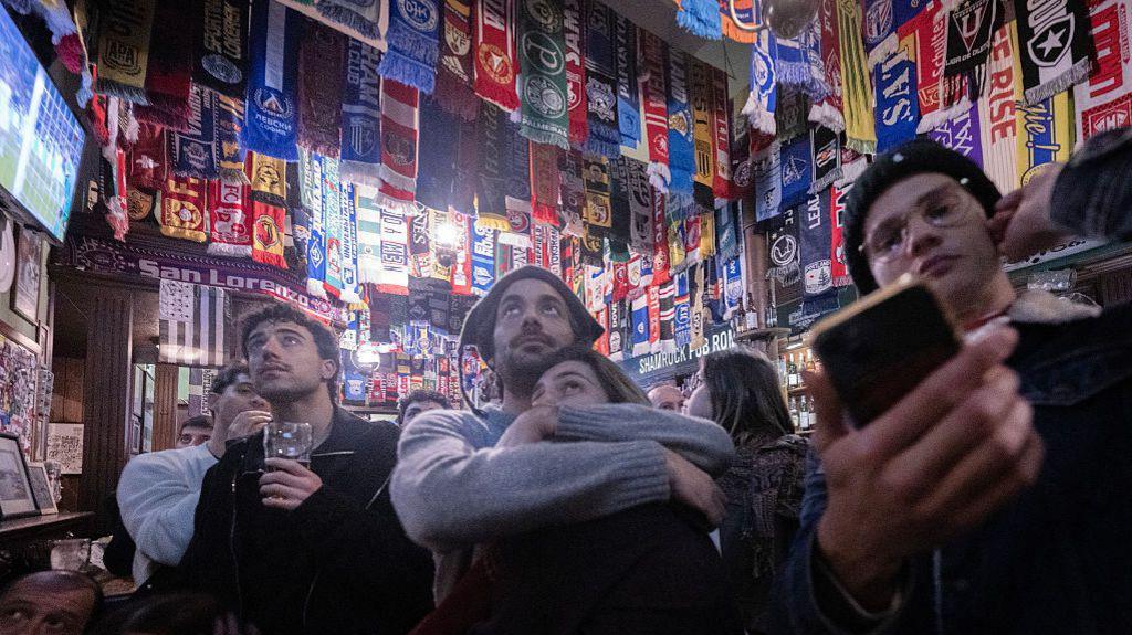 Italy fans watch the football in a pub
