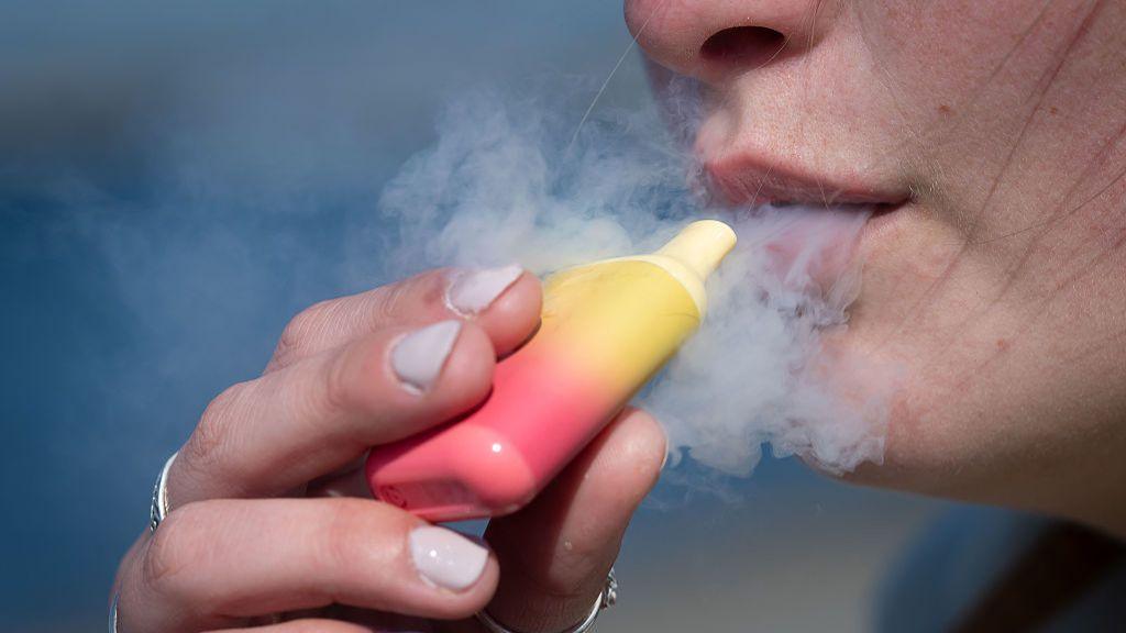  A woman poses for a photograph holding a single-use vape on April 5, 2025 in Cardiff, United Kingdom