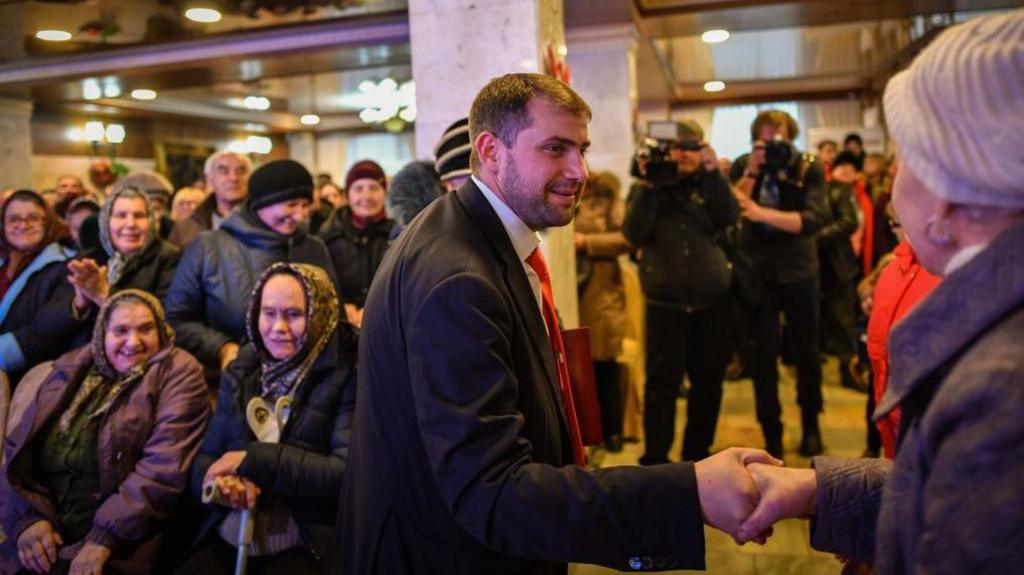 Ilan Shor - pictured here while running for election in 2019 - is seen shaking a woman's hand