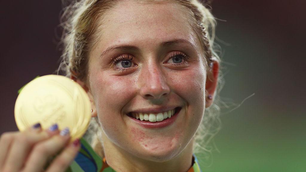 Close up of Laura Kenny smiling as she holds her Olympic Gold medal.