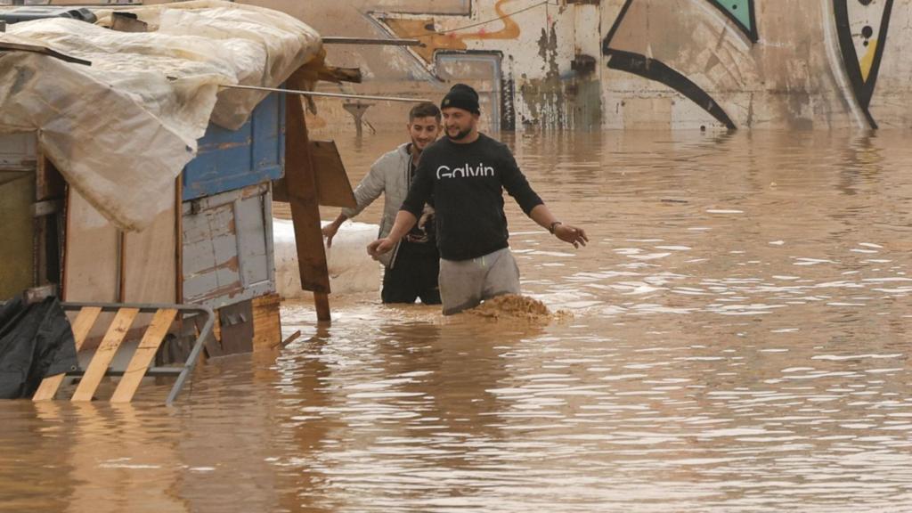 People walking through a flooded highway in the city of Valencia