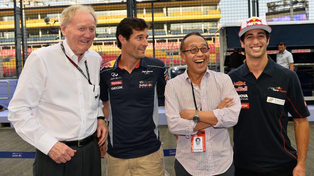 Four men standing side by side in front of an F1 race track. From left to right is Ron Walker, Mark Webber, Ong Beng Seng and Daniel Ricciardo