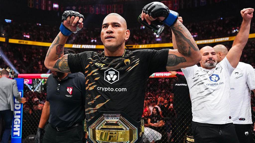 Alex Pereira flexing his biceps with the light-heavyweight UFC title around his waist