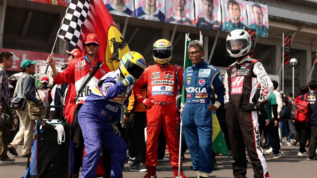 Fans dressed in Ayrton Senna race overalls and helmets at the Japanese Grand Prix