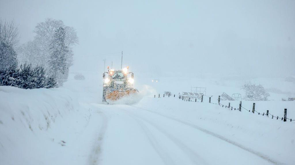 a tractor ploughing heavy snow from a road