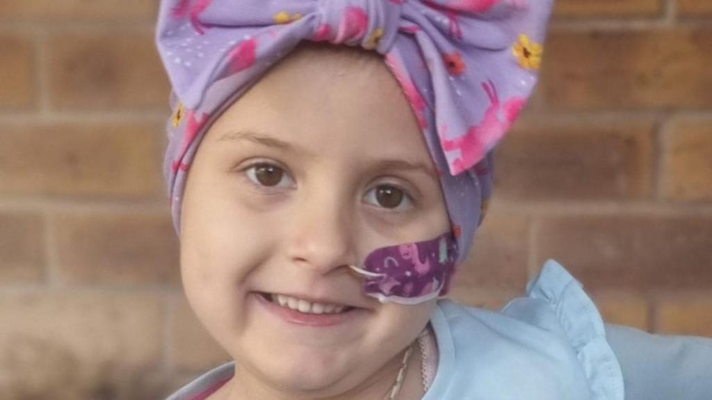 Lacie with a tube up her nose and wearing a hair wrap following chemotherapy