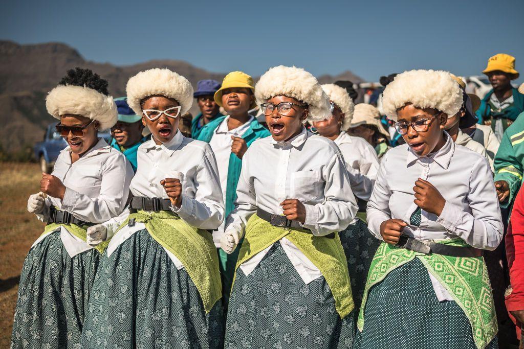 Women dressed in matching clothes stand together, singing and dancing - Wednesday 2 October 2024