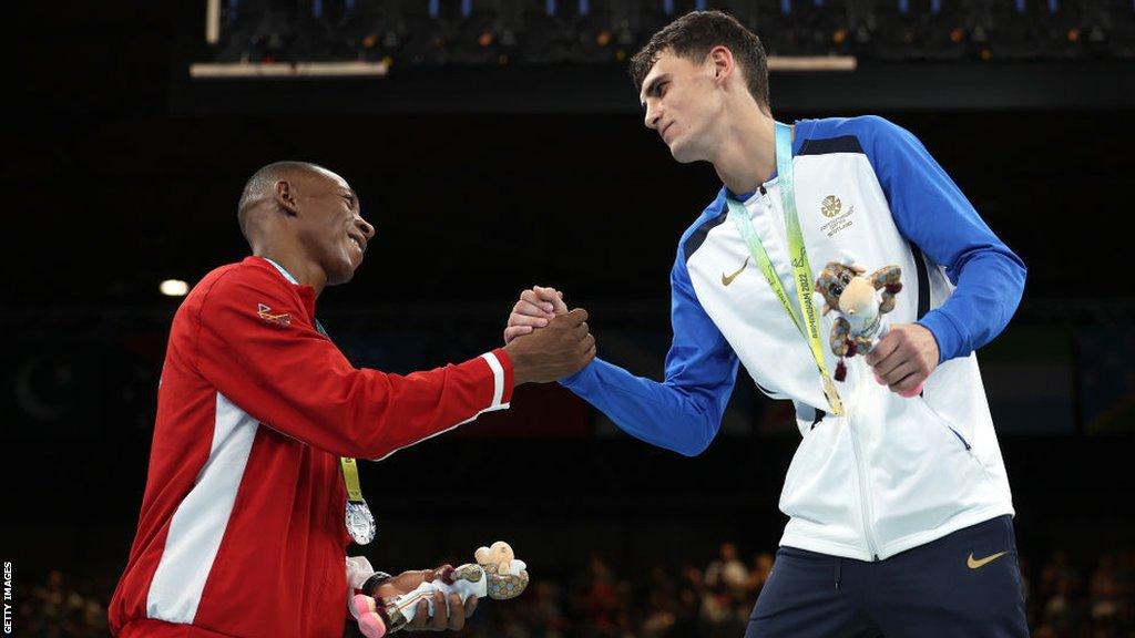 Silver medallist Louis Richarno Colin of Team Mauritius congratulates gold medallist Reese Lynch of Team Scotland during the men's boxing