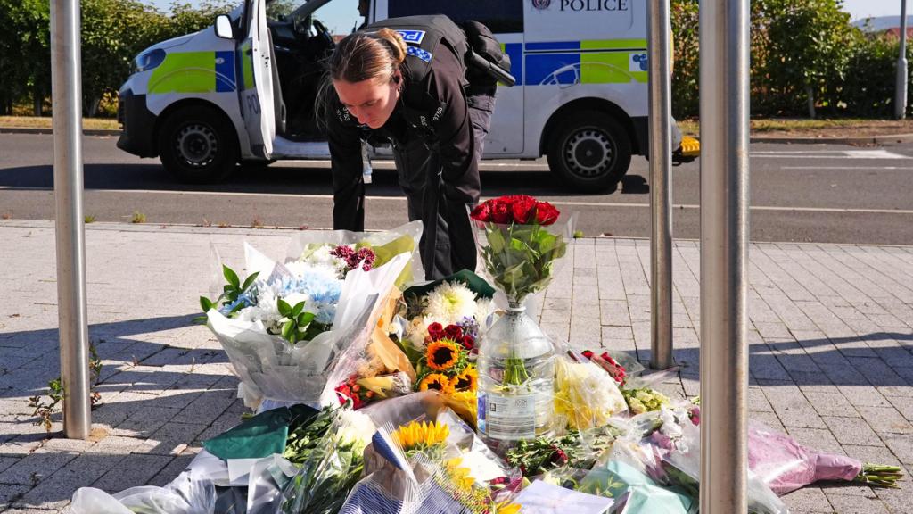 A police officer lays flowers