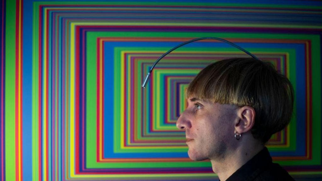 Neil Harbisson with an artwork featuring colourful rectangles