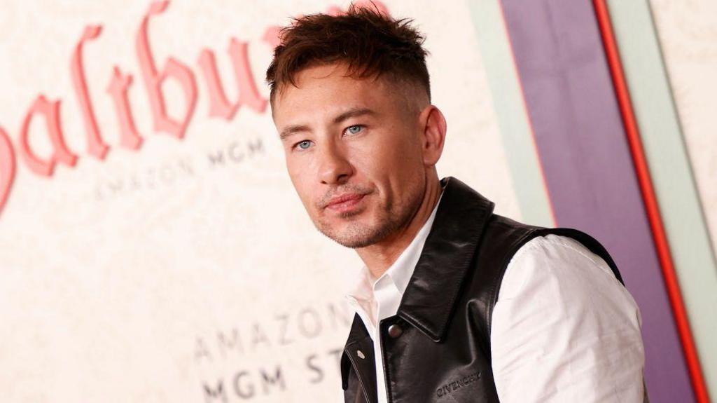 The actor Barry Keoghan at the premiere of Saltburn. He has short brown hair and is wearing a black waistcoat and white shirt.