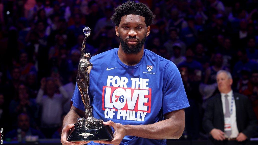 Joel Embiid holding the NBA MVP award in 2023